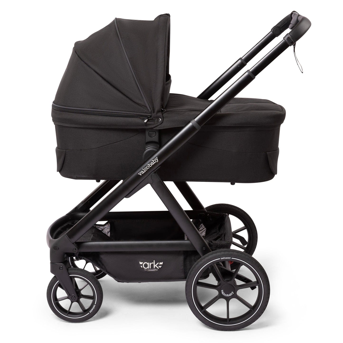 Black Valco OPEN BOX Ark bassinet by Valco Baby, side view with matte black frame, large wheels, and fabric canopy.