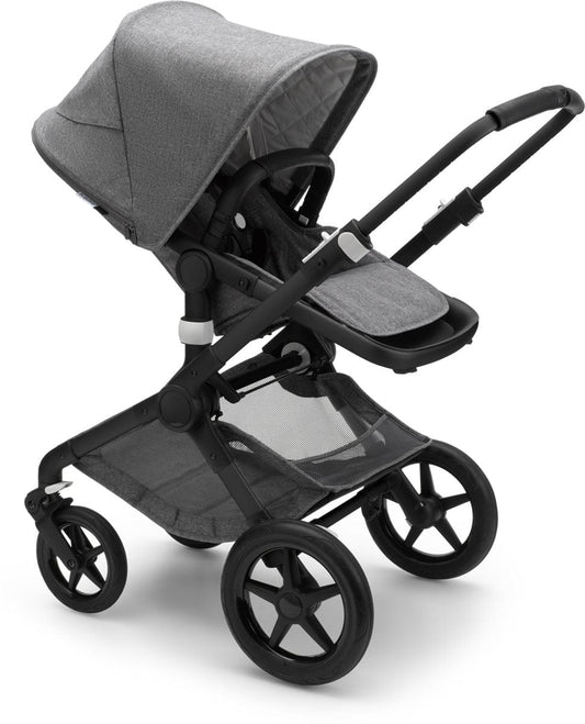 Black and grey melange Fox2 complete stroller by Bugaboo, featuring matching carrycot, textured fabric, and black frame with star-shaped wheels, shown in side view.
