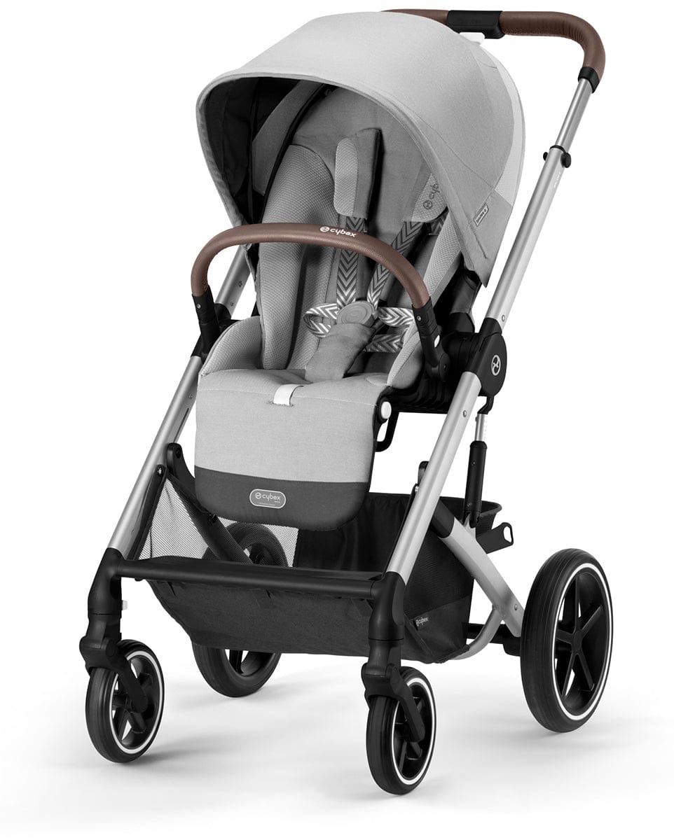 Silver frame stroller with lava grey fabric by Cybex, featuring brown leatherette handles, black wheels with white rims, and a spacious under-seat basket, shown in front three-quarter view.