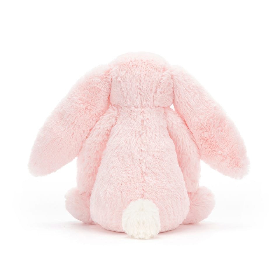 Back view of a Jellycat pink plush bunny with long ears and a white tail