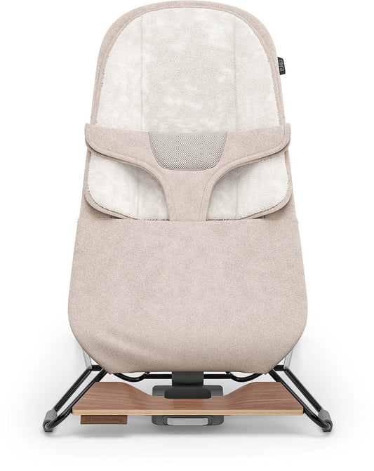 Sand melange fabric bouncer with black frame and walnut wood base by UPPAbaby, side view showing plush interior and textured upholstery