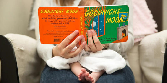 A parent reads "Goodnight Moon" to their baby, fostering a calming bedtime routine and a love of reading.
