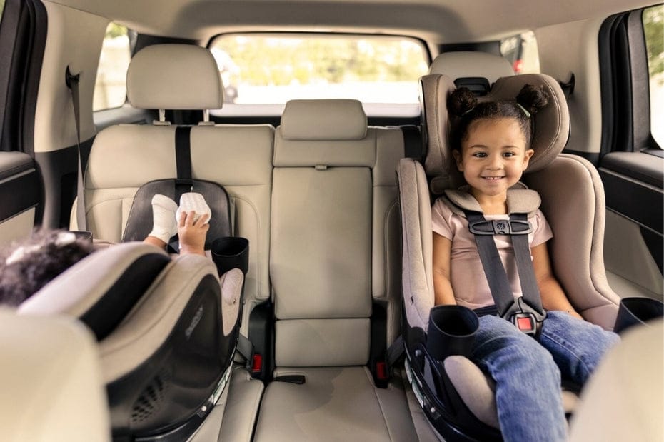 Smiling child secured in Britax Galaxy 360 Slim car seat, cozy backseat with cup holders, bright and safe family ride.
