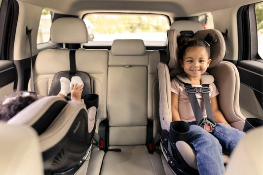 Smiling child secured in Britax Galaxy 360 Slim car seat, cozy backseat with cup holders, bright and safe family ride.
