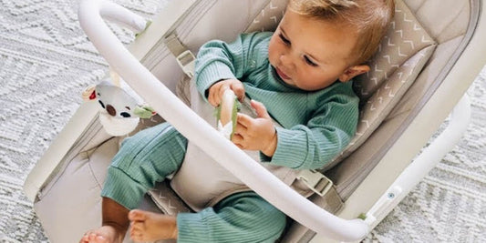 Content baby plays happily in a secure infant seat with a toy, giving parents peace of mind for a quick break.

