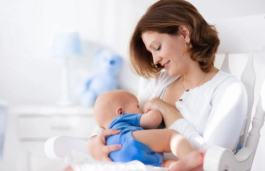 A serene scene of a mother tenderly breastfeeding her baby in a bright, cozy nursery rocking chair.
