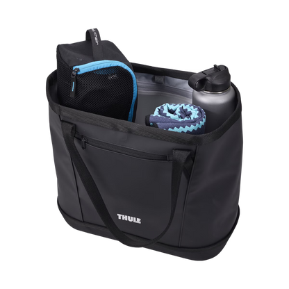 Black Thule Chasm Gear Tote 30L with mesh pocket, water bottle, and towel, side view, outdoor gear storage bag