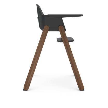 Side view of UPPAbaby high chair with dark grey seat and wooden legs