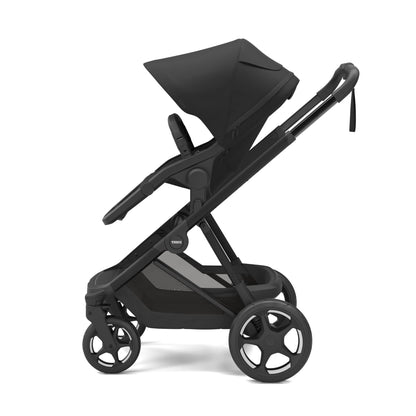 Black Thule stroller with canopy and storage basket viewed from the side