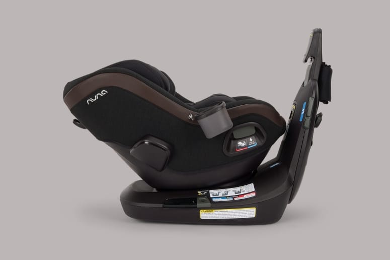 Black and brown Nuna baby car seat with side-impact protection, shown from rear angle on neutral background.