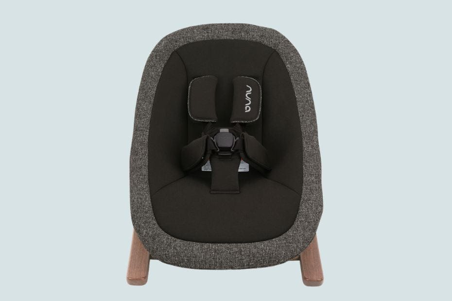 Gray and black Nuna baby car seat with wooden legs, front view, light background.