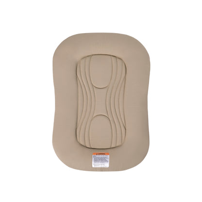Snuggle Me infant lounger in beige with central quilted padding and safety warning label