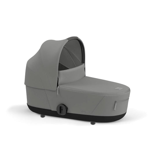 Mirage Grey infant cot by Cybex with soft fabric canopy, side view, black base, and zipped storage compartment