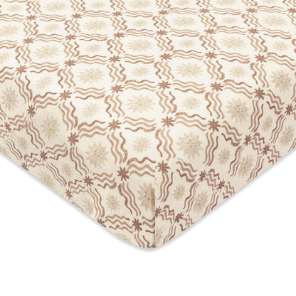 Babyletto crib sheet with brown wavy lines and star pattern on cream fabric