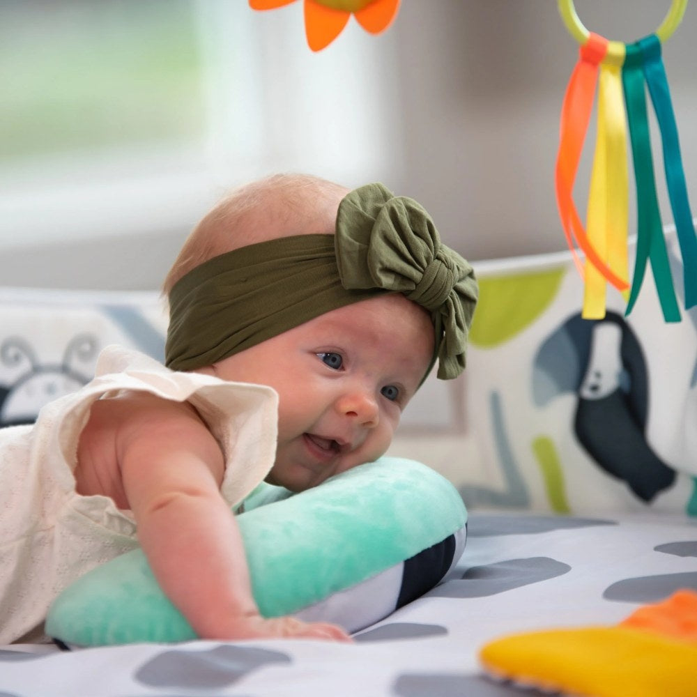 Baby using tummy time bolster on Sassy 3-in-1 Sensory Milestone Play Gym