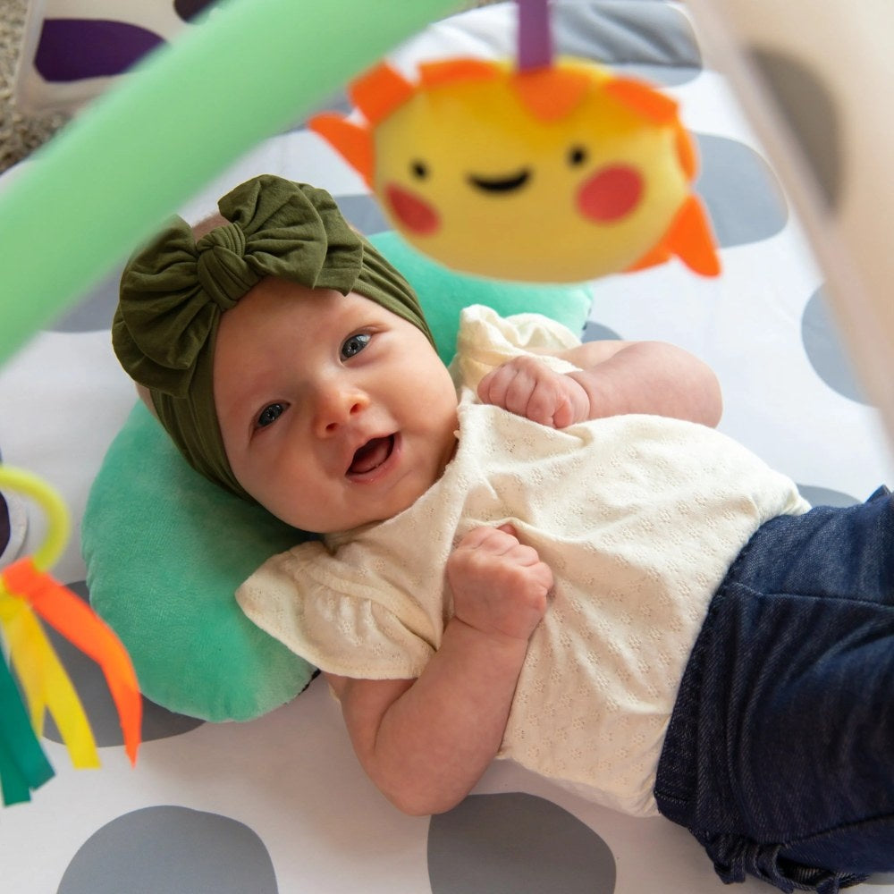 Baby smiling on Sassy 3-in-1 Sensory Milestone Play Gym