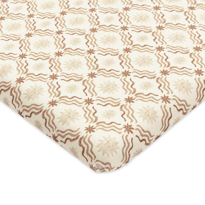 Babyletto crib sheet with a cream background and brown wavy line and star pattern
