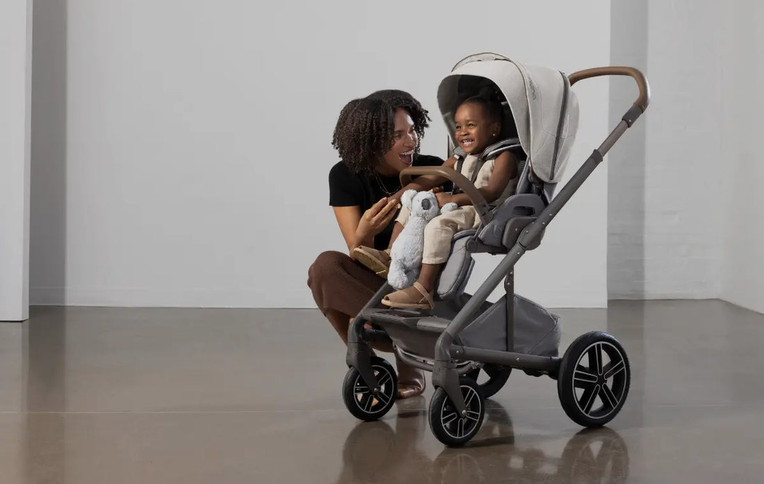 toddler girl in Nuna MIXX next stroller laughing with mom.