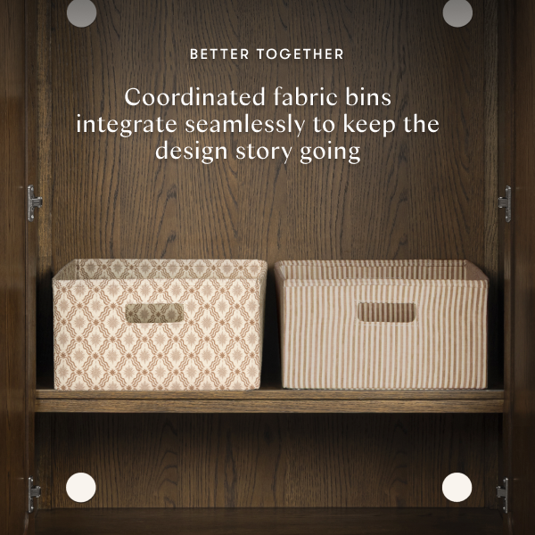 Two Babyletto fabric storage bins with patterned and striped designs on a wooden shelf