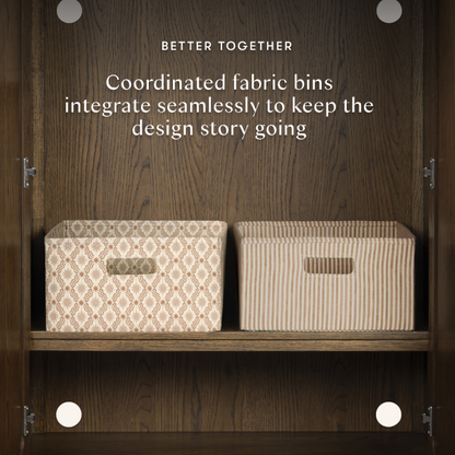 Two Babyletto fabric storage bins with patterned and striped designs on a wooden shelf