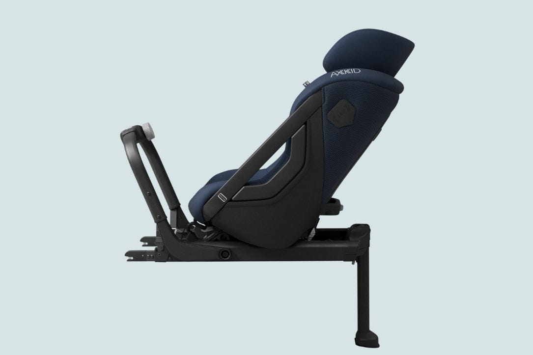 Dark blue Axkid child car seat with black frame, side view, light gray background.