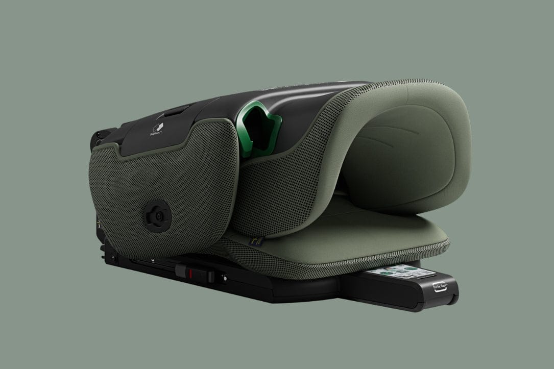 Dark green and black car seat with mesh sides, padded headrest, and green buckle, on solid background.