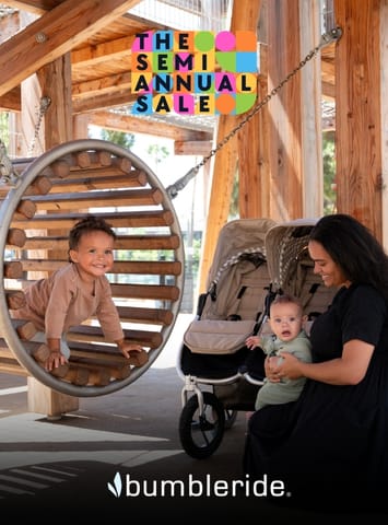 Child in wooden swing next to woman holding baby in Bumbleride stroller with semi annual sale graphic