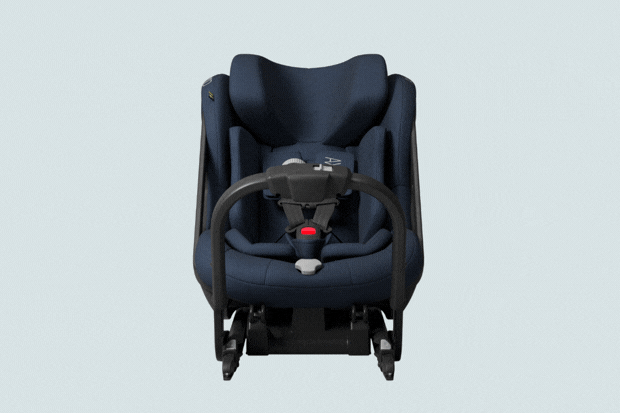 Dark blue child car seat with black harness and red buckle, viewed front-on against light gray background.
