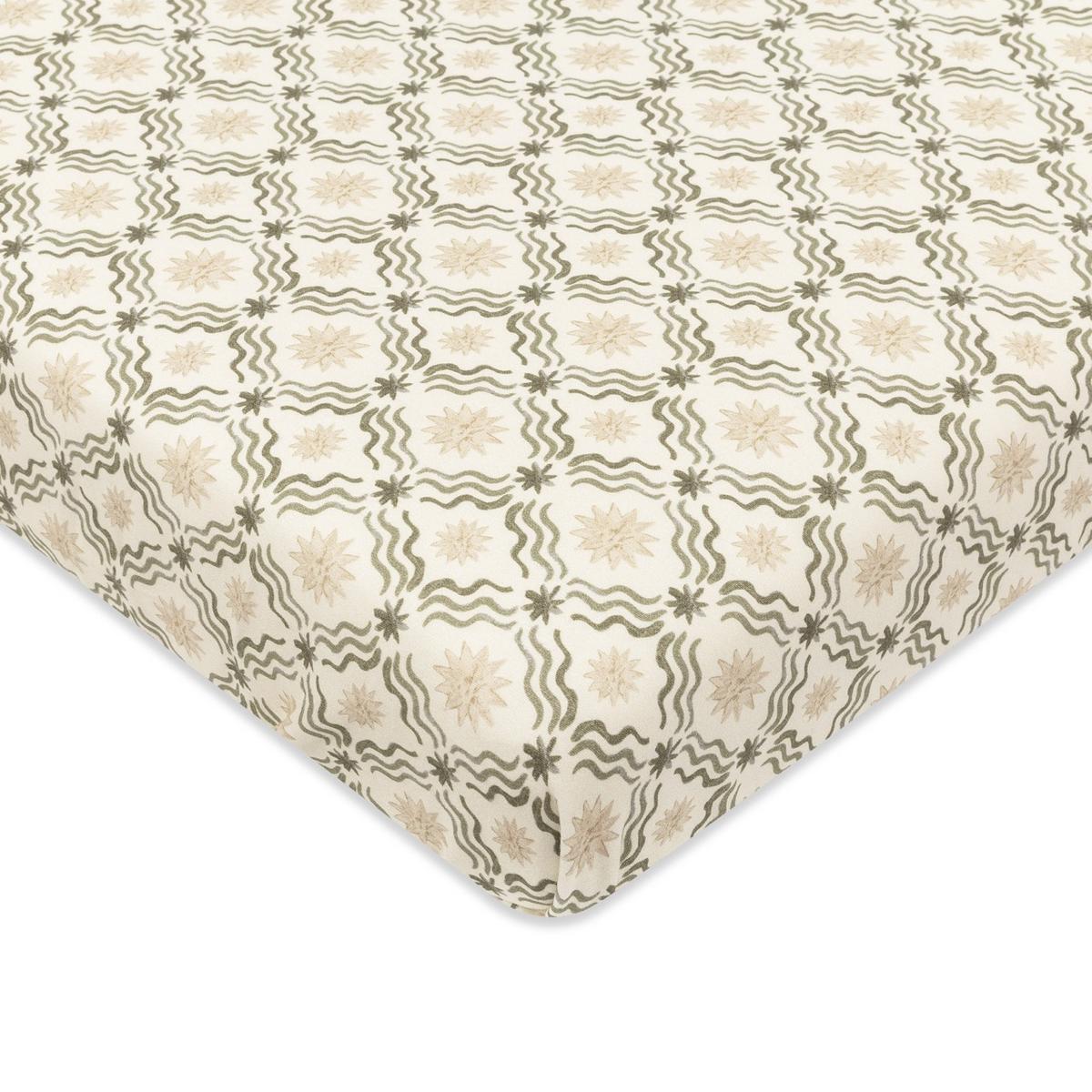 Babyletto crib sheet with cream background and repeating olive green wavy line and star pattern
