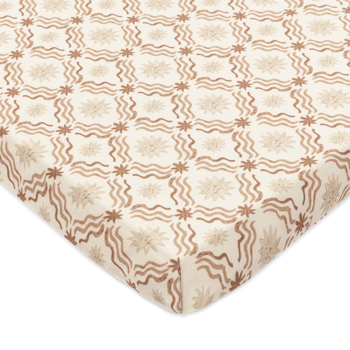 Babyletto crib sheet with tan wavy lines and star patterns on cream fabric