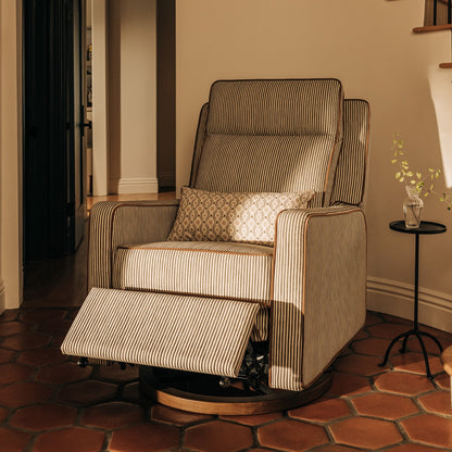 Babyletto striped recliner with a patterned lumbar pillow on a terracotta tile floor