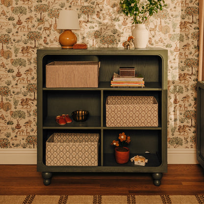 Babyletto green wooden bookcase with storage baskets and decorative items