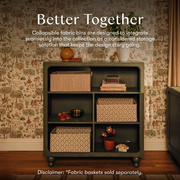 Babyletto dark green wooden bookshelf with patterned fabric storage bins on shelves