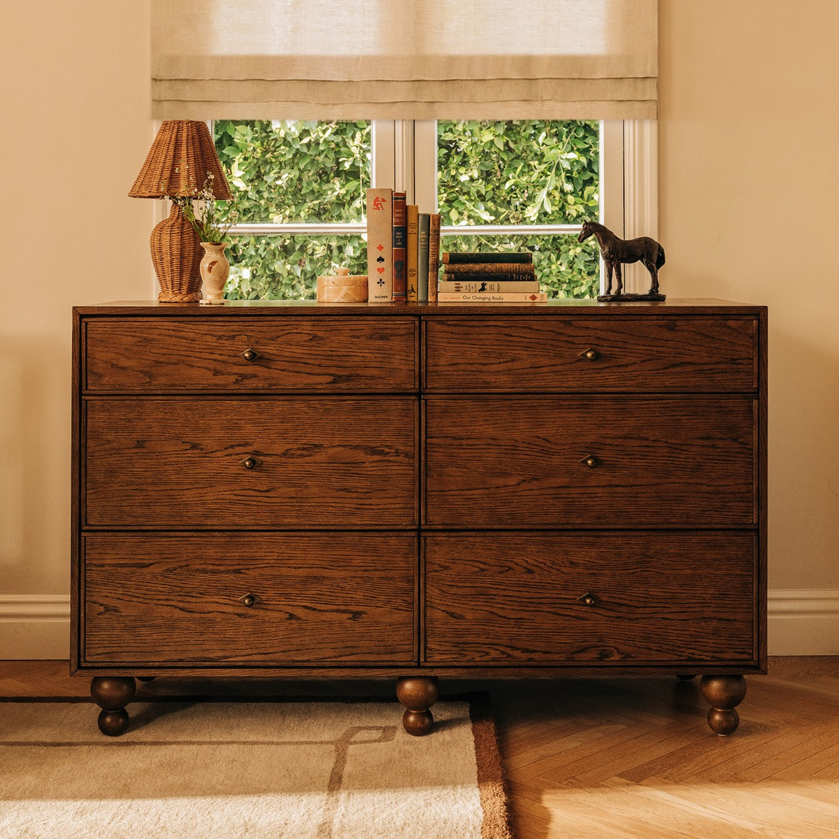 Babyletto six drawer wooden dresser with round feet and brass hardware