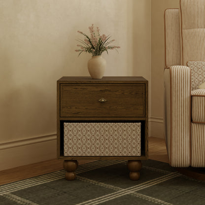 Babyletto wooden nightstand with one drawer and an open shelf containing a patterned storage bin