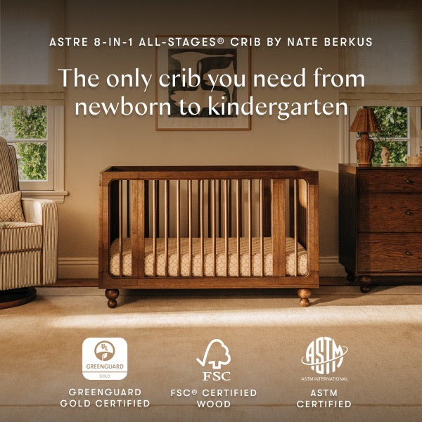 Babyletto Astre 8-in-1 all-stages crib in a nursery room with certification logos