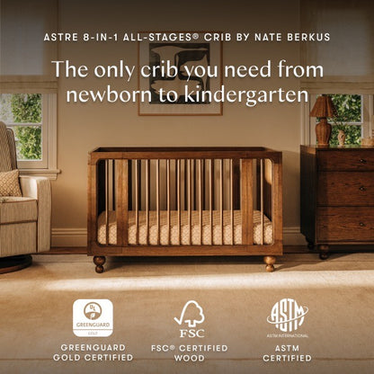 Babyletto Astre 8-in-1 all-stages crib in a nursery room with certification logos