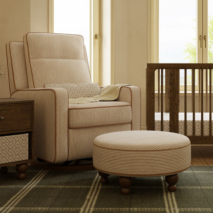 Babyletto striped nursery glider and matching round ottoman in a room with a wooden crib