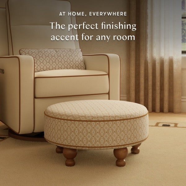 Babyletto round patterned ottoman with wooden feet in front of a matching armchair