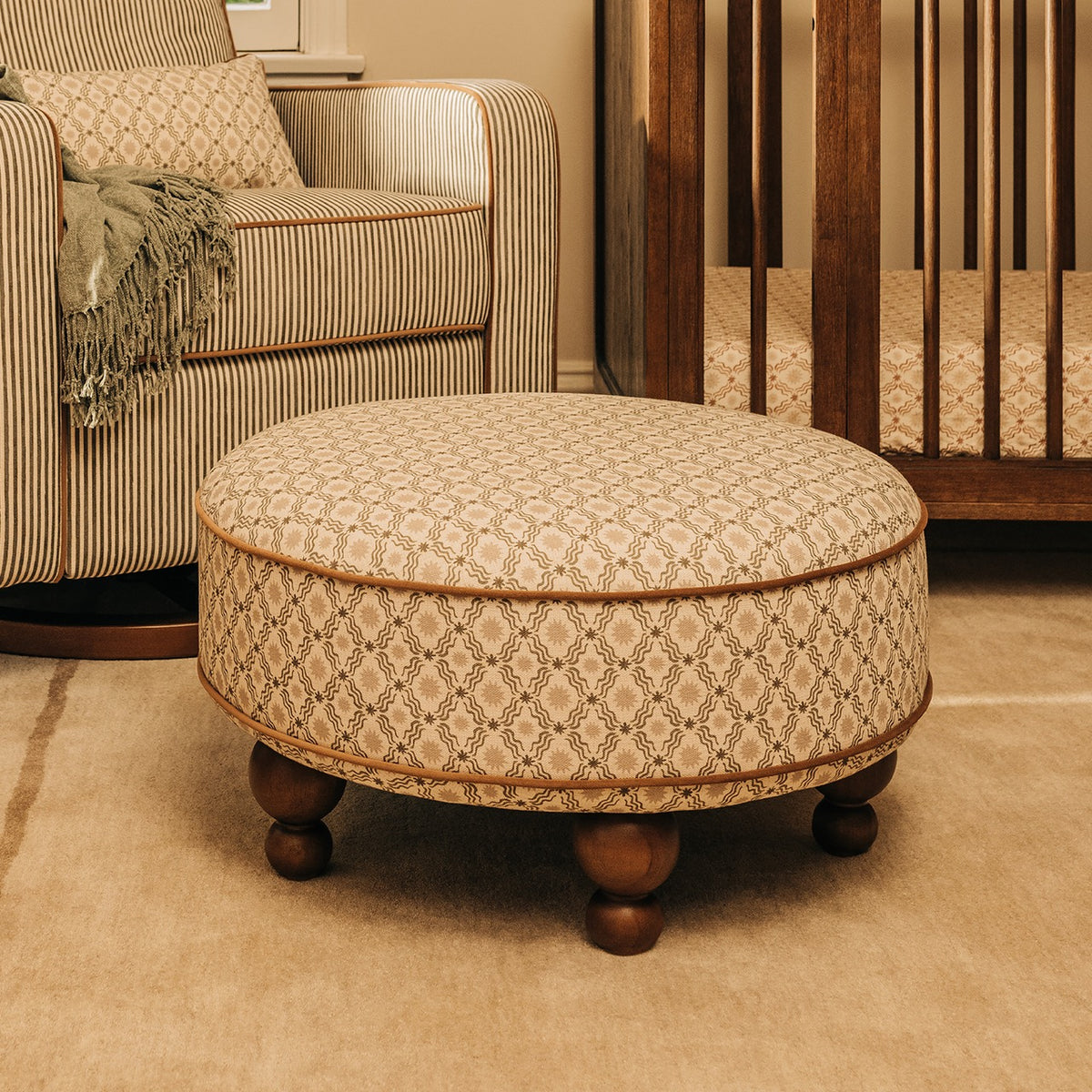 Babyletto round patterned ottoman with wooden feet in a nursery