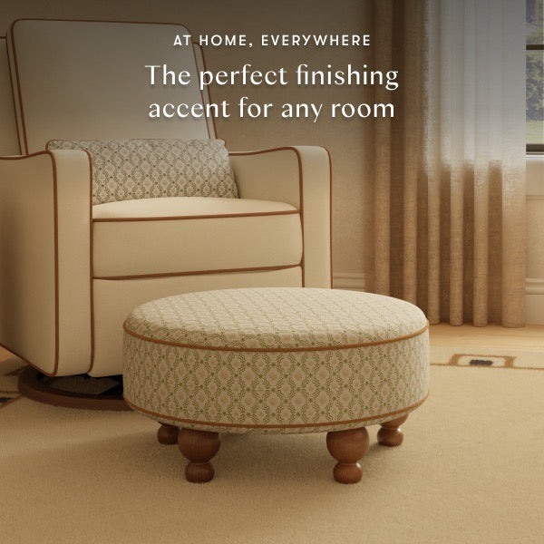 Babyletto round patterned ottoman with wooden feet in front of a matching armchair
