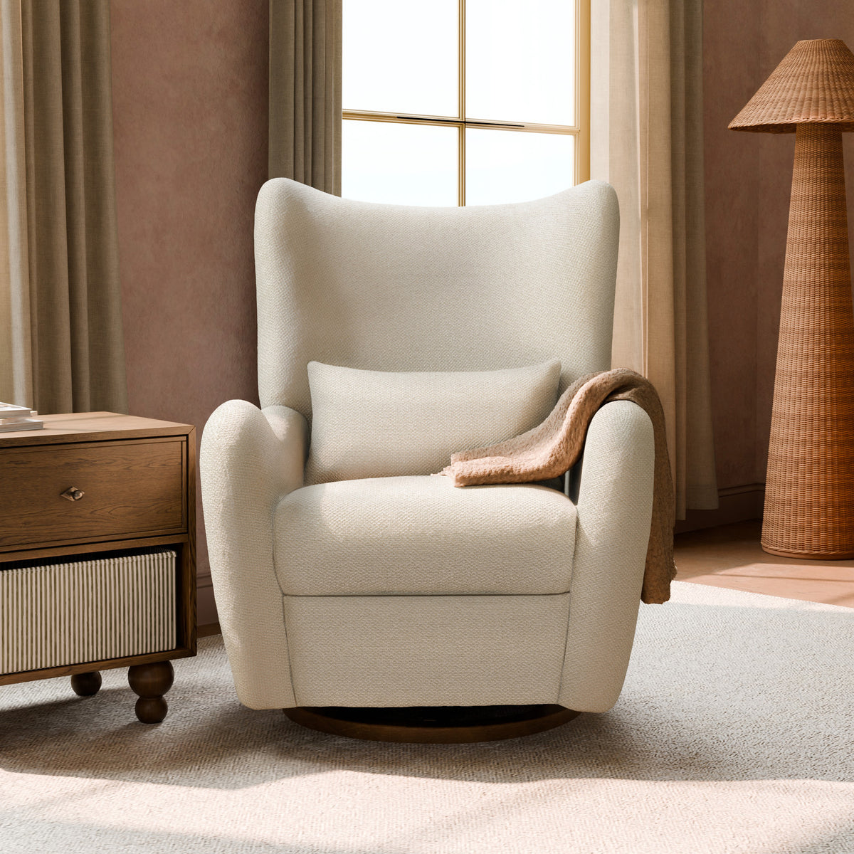 Babyletto cream wingback swivel glider chair with lumbar pillow and throw blanket