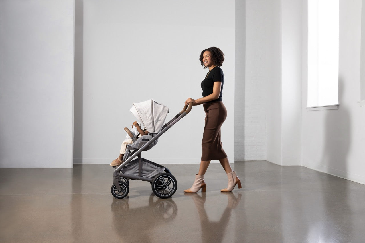 Woman pushing a Nuna stroller with a child inside