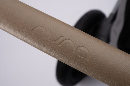 Tan leatherette Nuna stroller handlebar with embossed logo