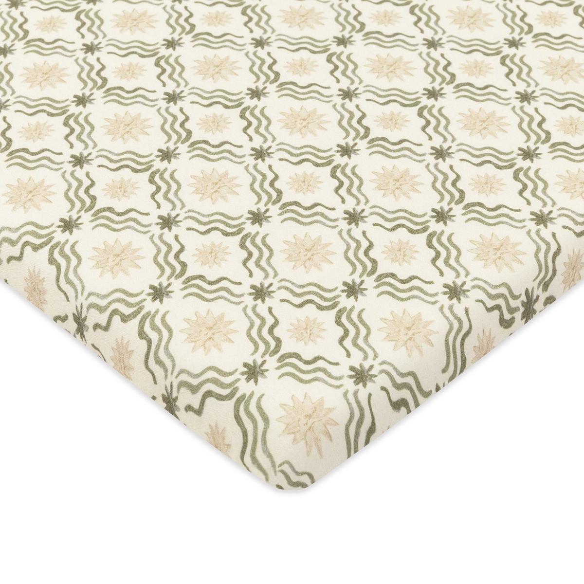 Babyletto crib sheet with green wavy lines and beige star pattern on cream background