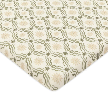 Babyletto crib sheet with green wavy lines and beige star pattern on cream background