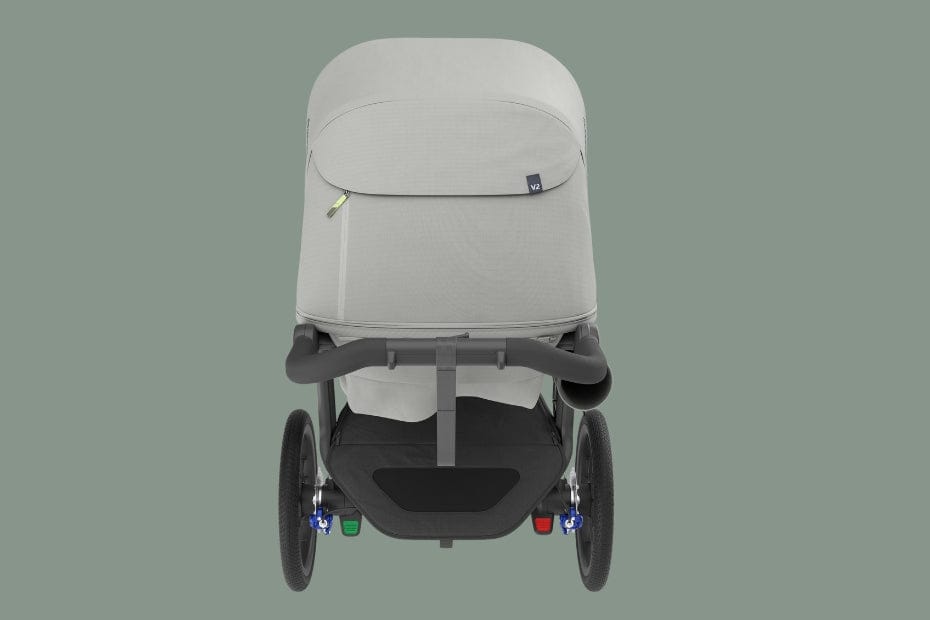 Light gray baby stroller with black frame and wheels, viewed from rear against muted green background.