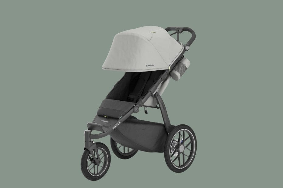 Modern gray stroller with white canopy, black seat, and large wheels, labeled "RIDGE" on frame, against muted green background.
