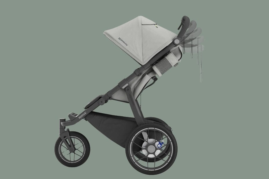 Modern gray stroller with large front wheel, canopy, and "Buggie" branding on frame, set against muted green background.