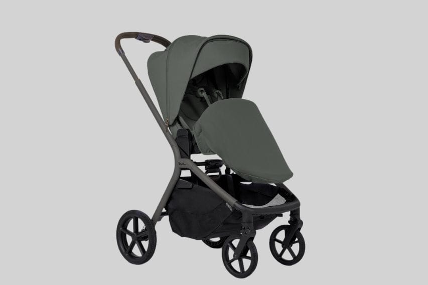 A green stroller with a black storage basket is centered on a light gray background. The stroller has a sun shade and four wheels.